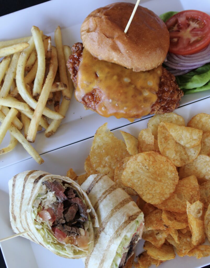Crispy chicken sandwich with melted cheddar cheese served with French fries and a steak wrap with kettle chips at River Oaks Golf Course in Cottage Grove Minnesota