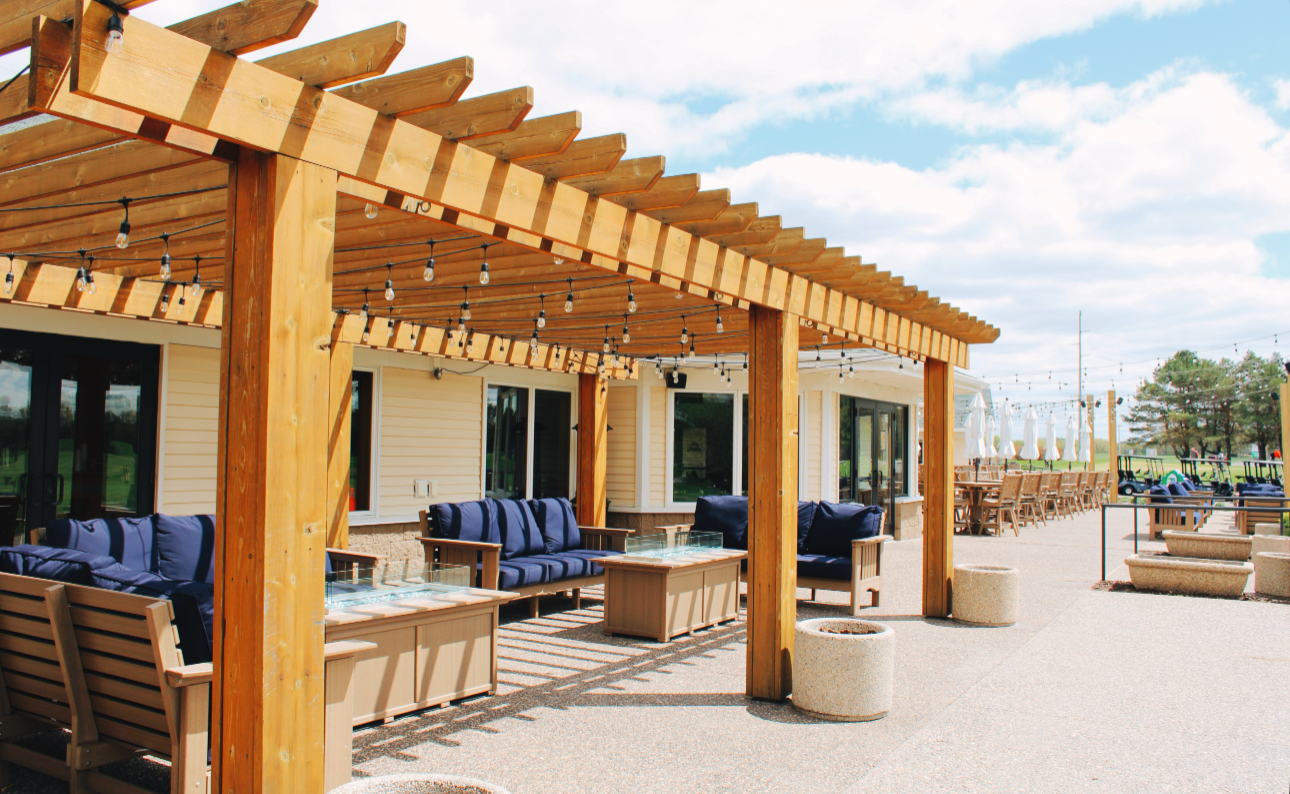 Outdoor patio with pergola seating, string lights, and lounge furniture at River Oaks Golf Course and Event Center in Cottage Grove Minnesota