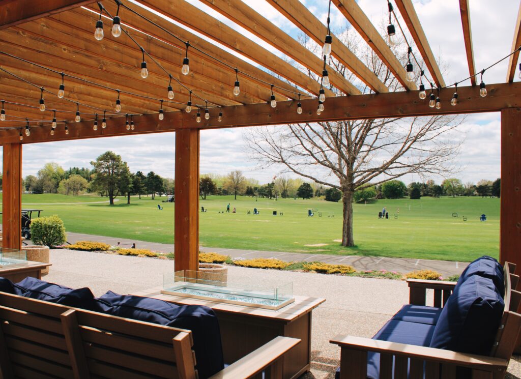 Covered patio seating overlooking golf course and driving range at River Oaks Golf Course in Cottage Grove Minnesota
