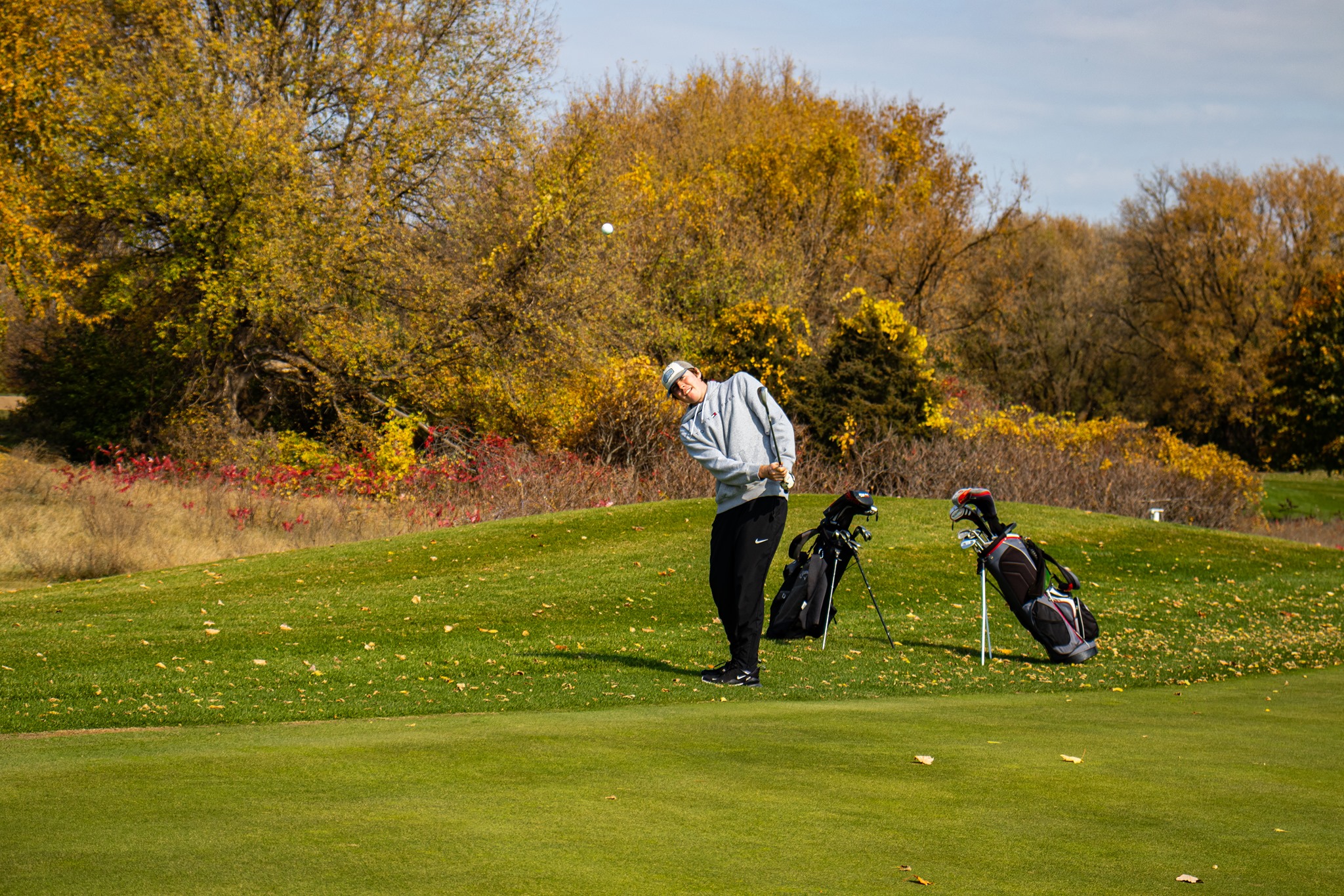 Junior Golfer playing a shot on the course during fall at River Oaks Golf Course in Cottage Grove Minnesota